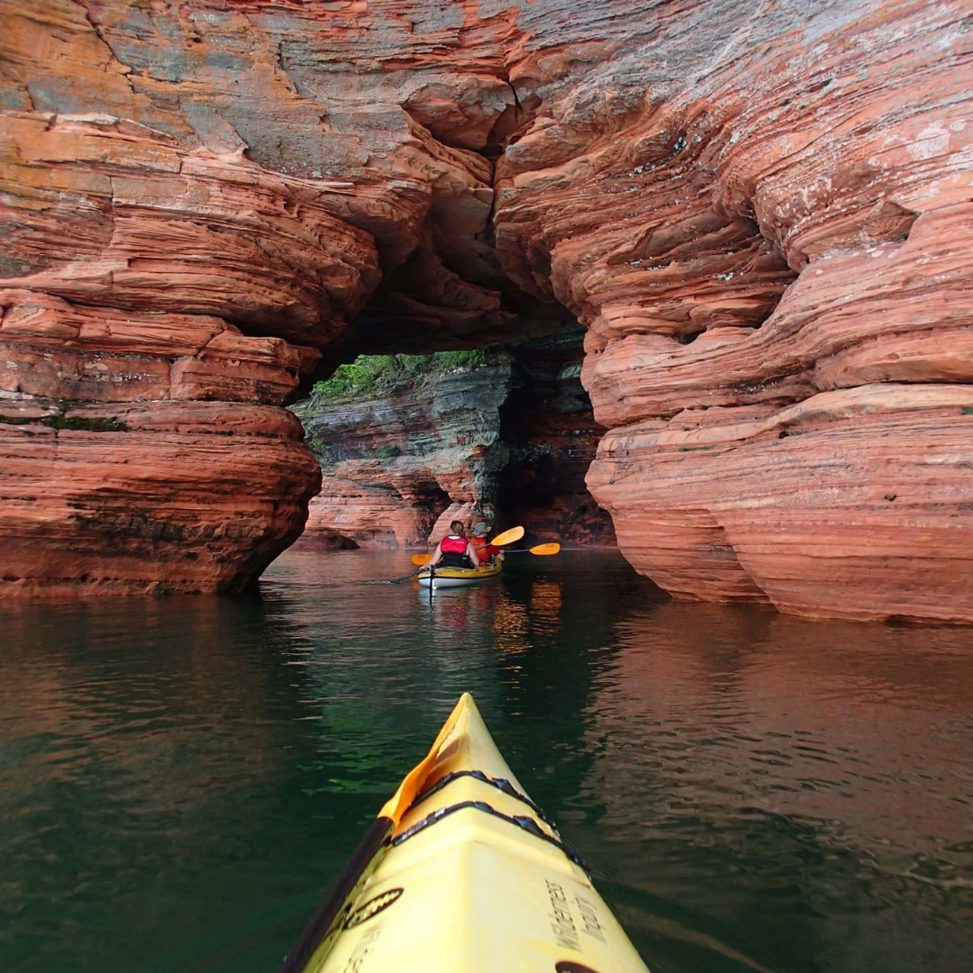 Adventurous individuals exploring the vibrant fall colors of Lake Superior's South Shore, both on land with ATVs and bikes and on water with kayaks.